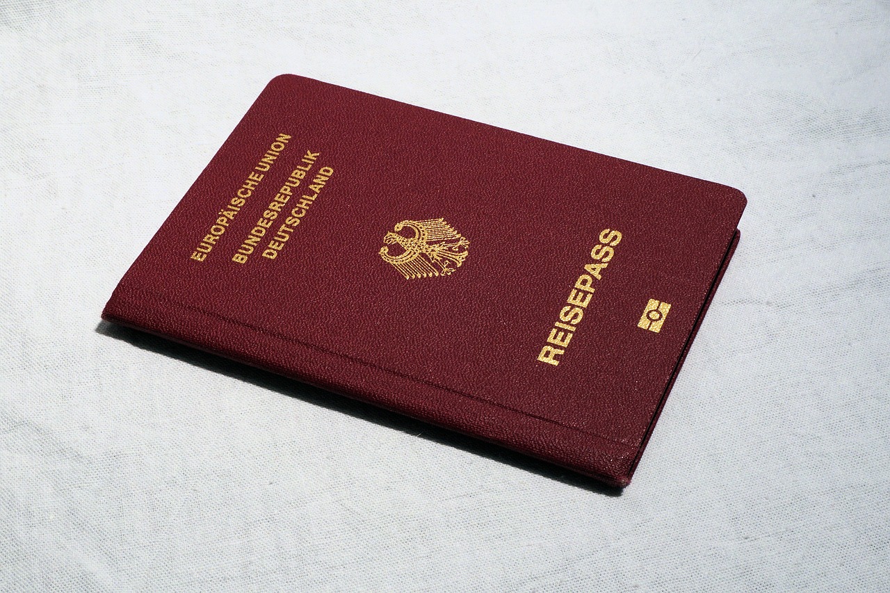 Czerwony paszport leżący na białym tle
