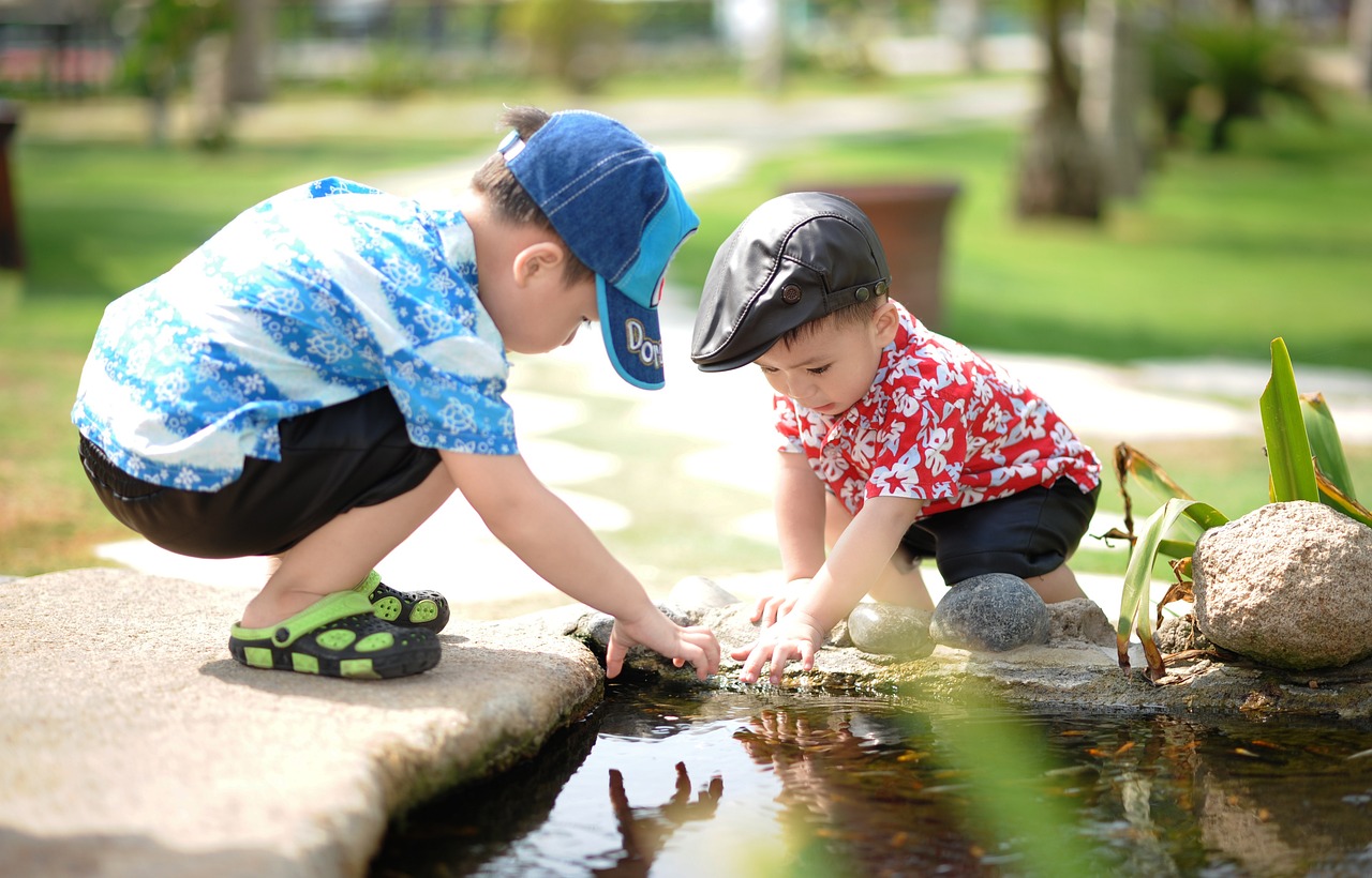 Dwóch małych chłopców bawiących się w oczku wodnym w Gnieźnie