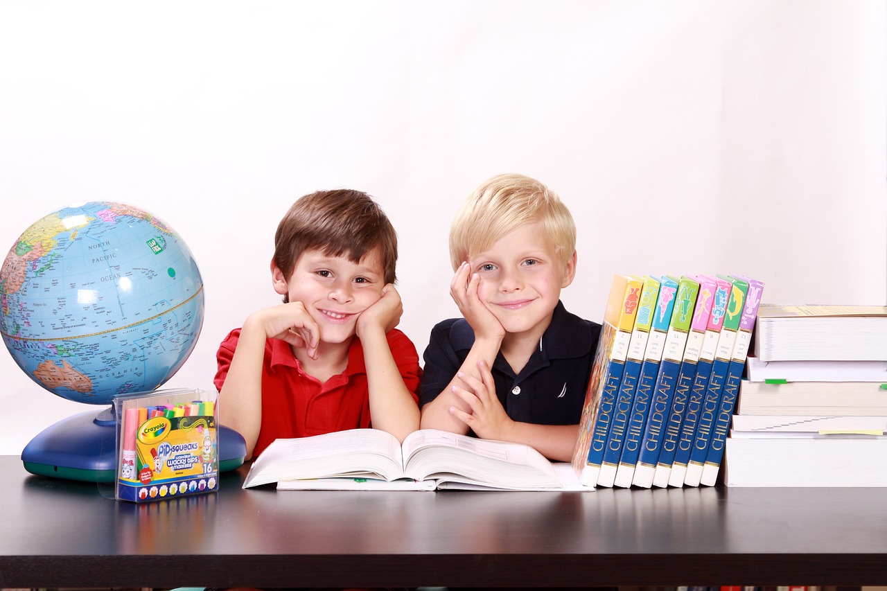 Dwóch małych chłopców siedzących przy stoliku w szkole w Gnieźnie
