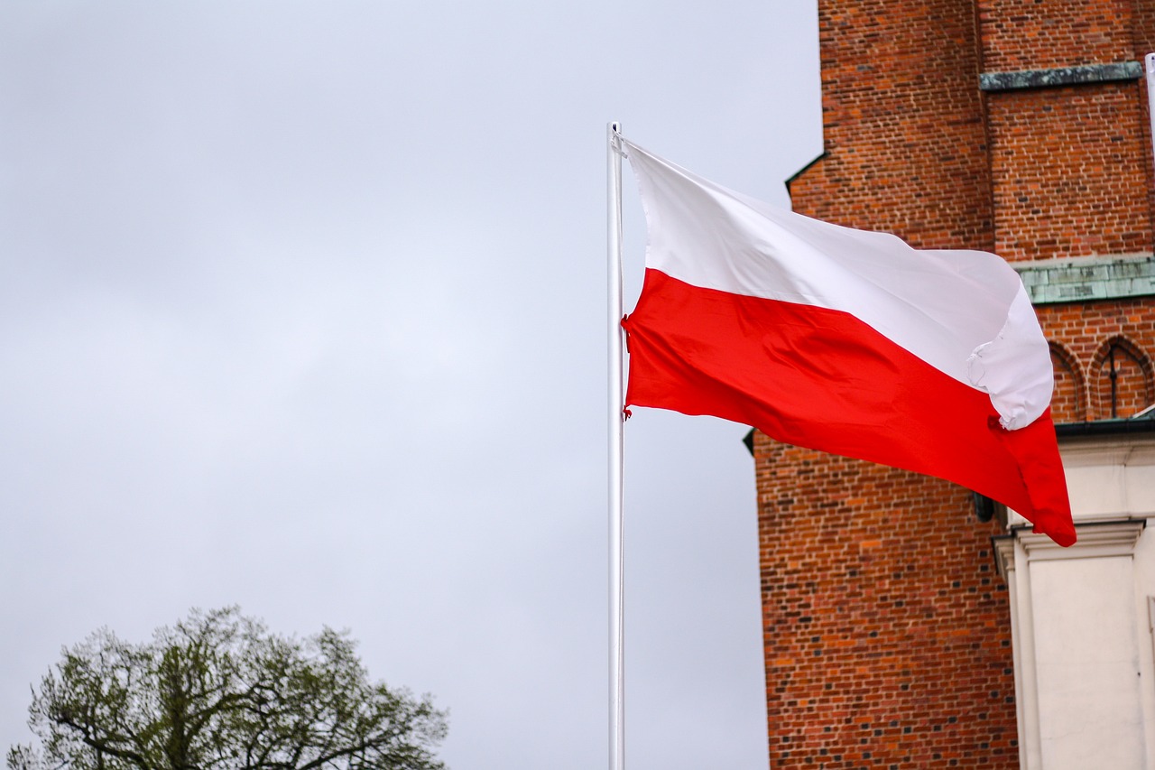 Flaga Polski powiewająca na tle Katedry Gnieźnieńskie w Gnieźnie