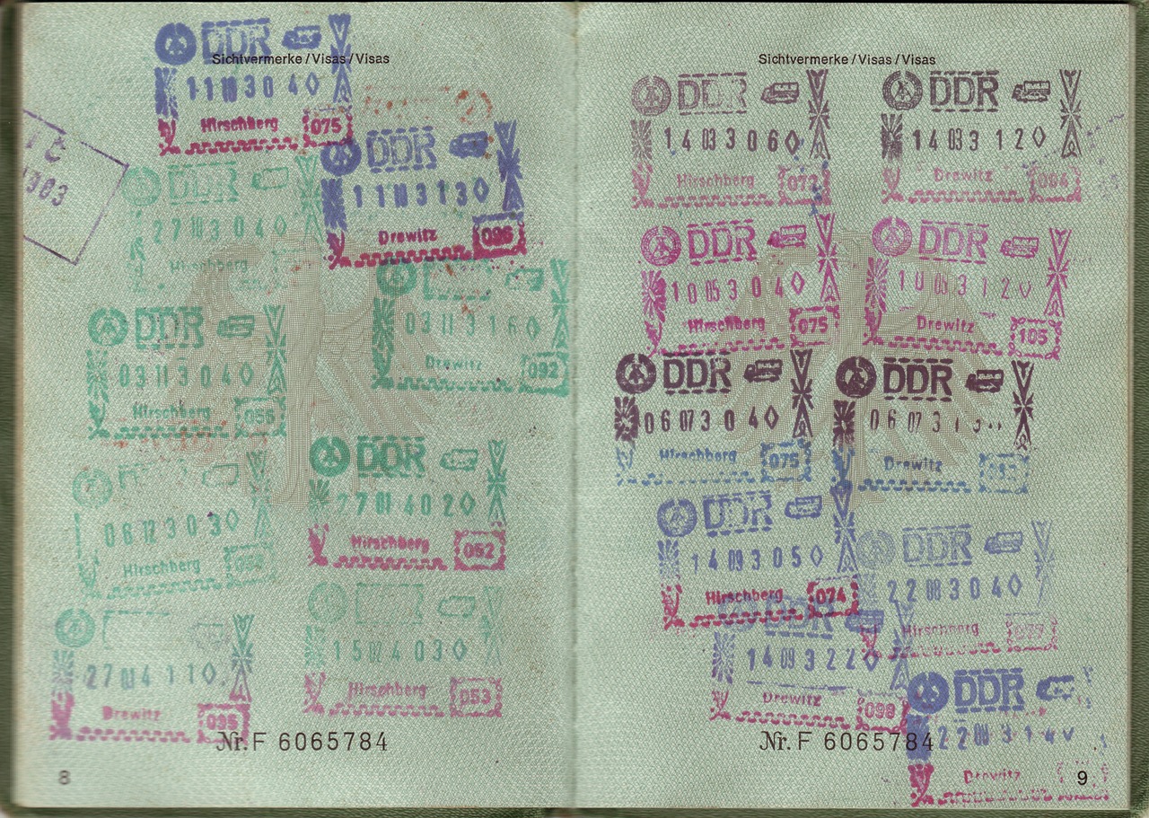 Kolorowe pieczątki przybite w otwartym paszporcie